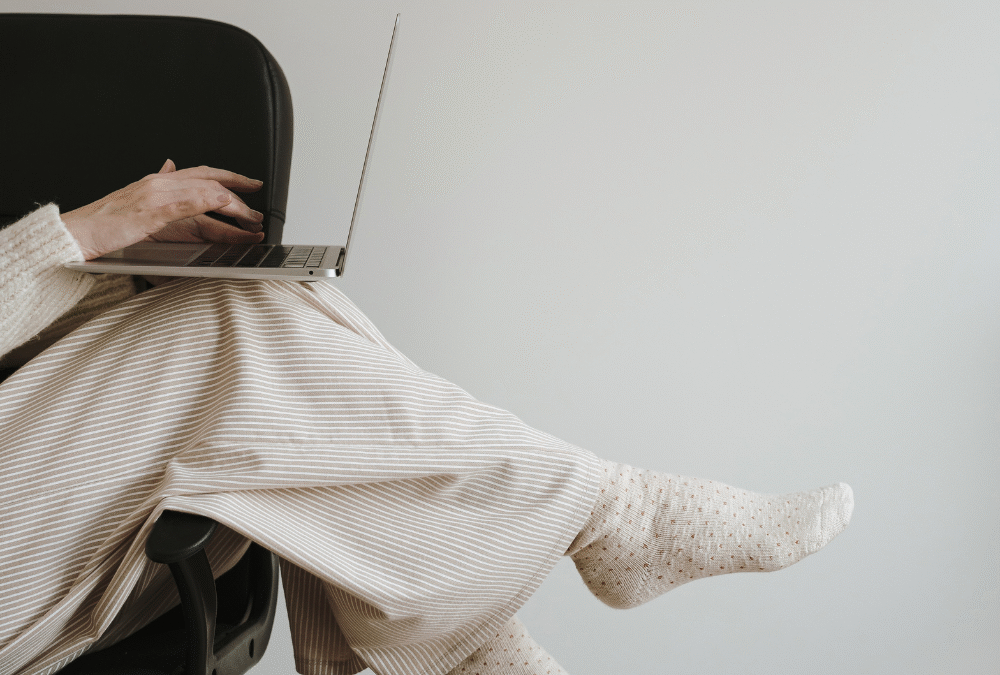 Women sitting cross legged on chair with laptop. Burnout small business owner