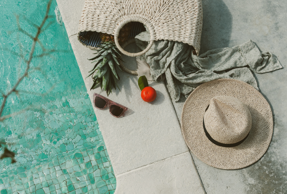 Pool with beach bag and hat. Managing business in summer with kids.