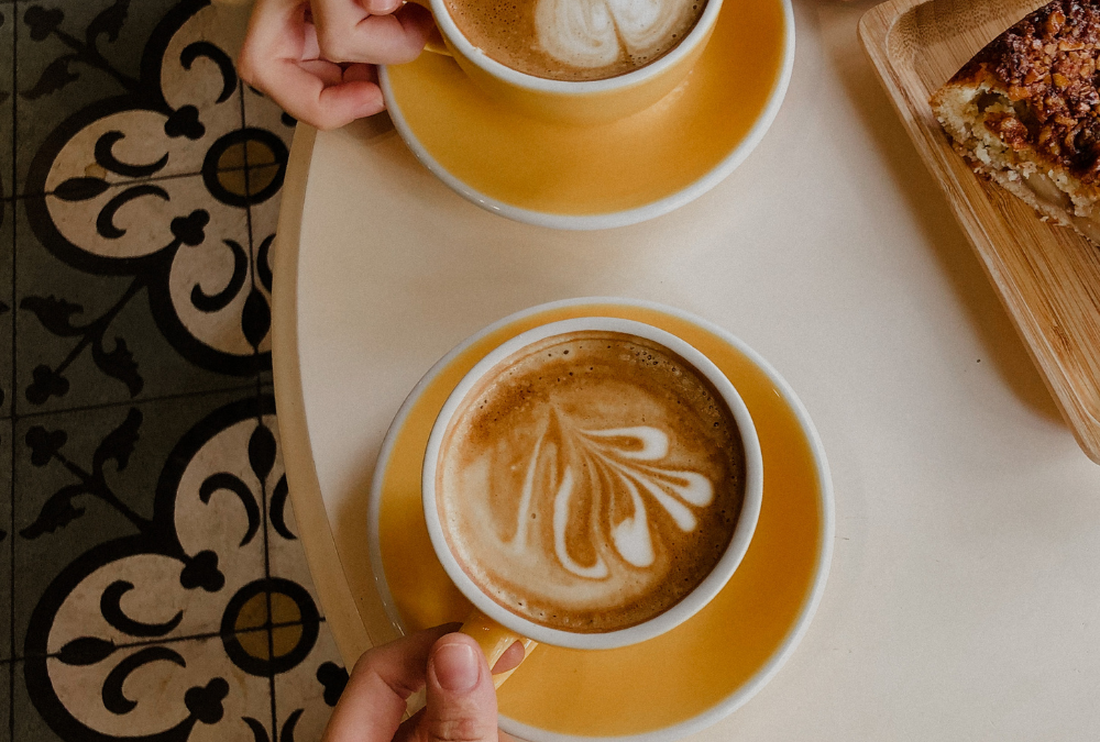 Hands holding coffee at a local cafe. Building a business community.